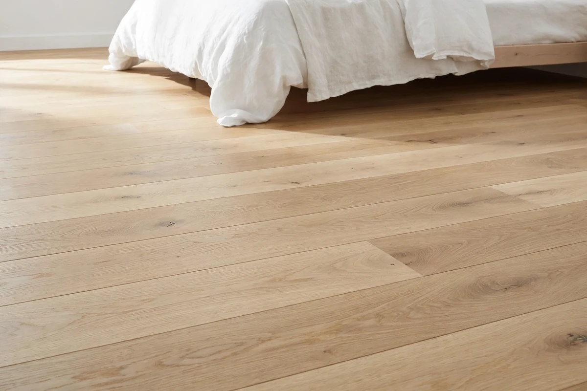 Light oak wood plank flooring in a bright Scandinavian bedroom with soft daylight