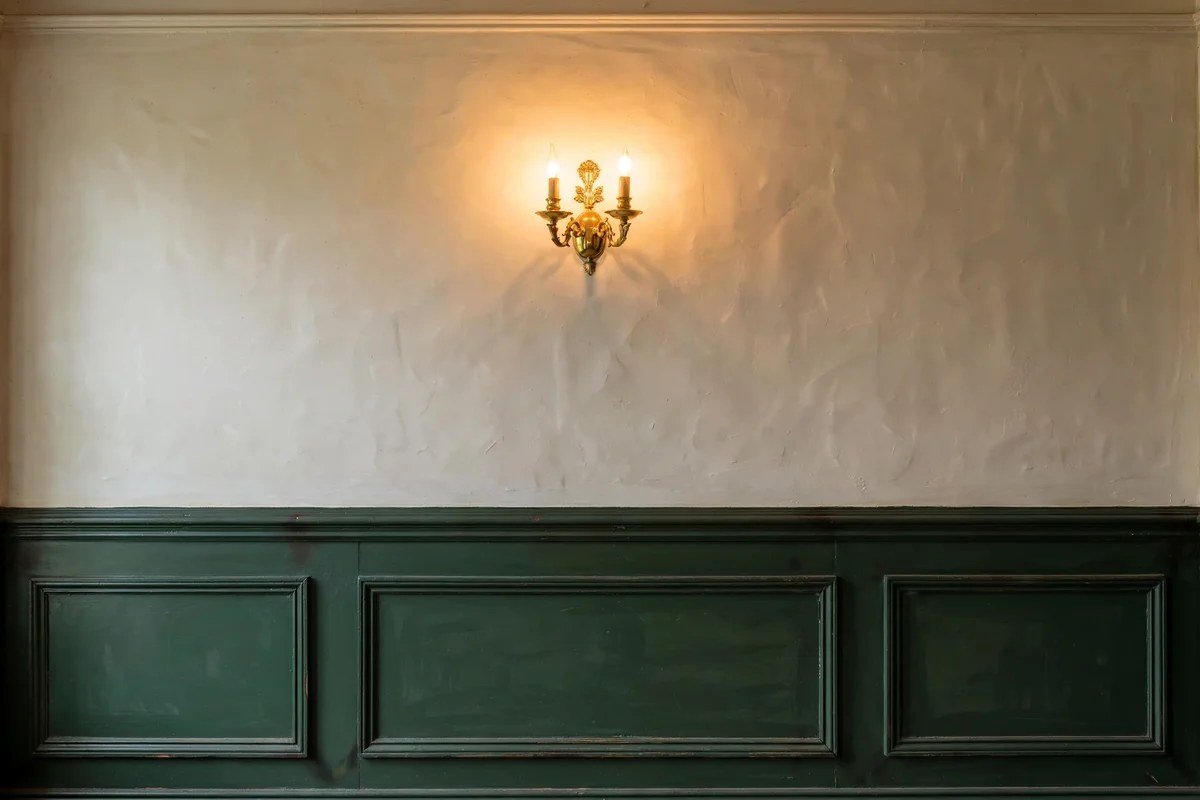 Green wainscoted wall panels with picture frame molding in a Victorian living room